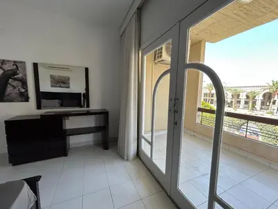 a room with a glass door with a desk and a window at Pause for a while in Hurghada