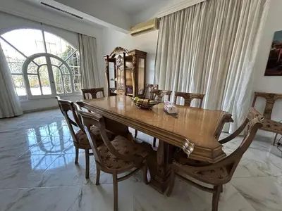 a dining room with a wooden table and chairs at Pause for a while in Hurghada