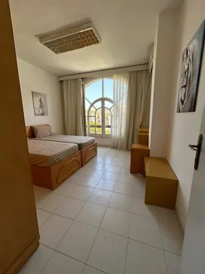 a bedroom with a bed and a large window at Pause for a while in Hurghada