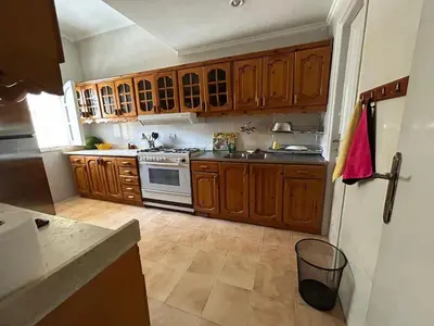 a kitchen with wooden cabinets and a stove at Pause for a while in Hurghada