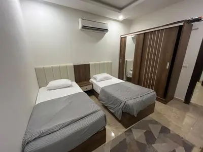 a room with two beds and a mirror in it at شاليه في قرية ميراج in Hurghada