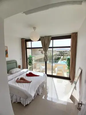 a bedroom with a bed and a large window at Gcribs Onebedroom Elgouna in Hurghada
