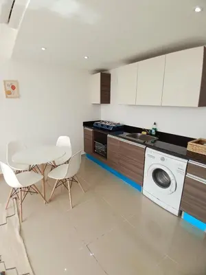 a kitchen with a washing machine and a table and chairs at Gcribs Onebedroom Elgouna in Hurghada
