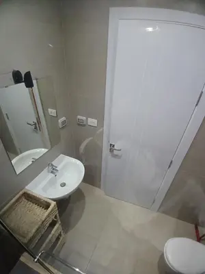 a white bathroom with a sink and a shower at Gcribs Onebedroom Elgouna in Hurghada