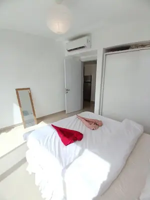 a white bed with a red robe on top of it at Gcribs Onebedroom Elgouna in Hurghada