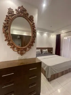 a bedroom with a bed and a mirror on the wall at Florenza Khamsim 307 in Hurghada