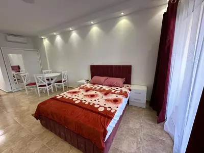 a bedroom with a bed and a table and chairs at Cozy studio in Florenza Khamsim - I409 in Hurghada
