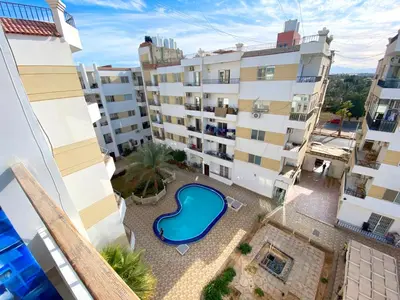 an apartment with a swimming pool in a building at Studio Lotus Compound Kawser in Hurghada