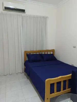 a bedroom with a bed with blue sheets and a window at Studio Lotus Compound Kawser in Hurghada
