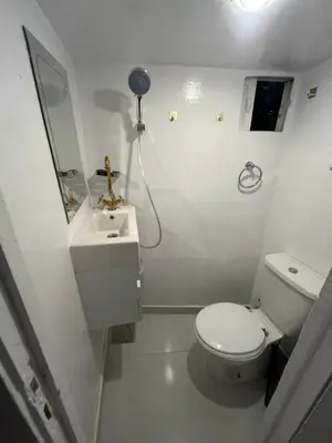 a white bathroom with a toilet and a sink at Aswan felucca sailing boat in Aswān