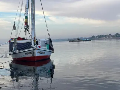 a sail boat sitting in the water on the water at Aswan felucca sailing boat in Aswān