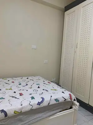 a bedroom with a bed with a comforter on it at Sun live Holiday in Hurghada