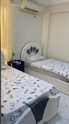 a bedroom with two beds with colorful confederacies at Sun live Holiday in Hurghada