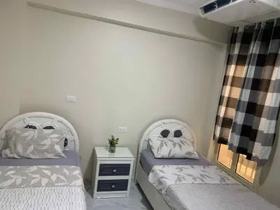 a bedroom with two beds and a night stand at Sun live Holiday in Hurghada