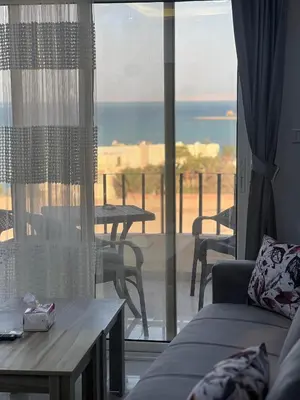 a living room with a couch and a view of the ocean at Modern Beachfront Apartment 2 in Hurghada