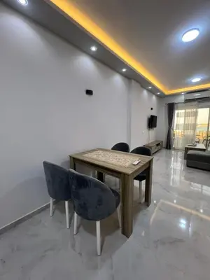 a living room with a wooden table and chairs at Modern Beachfront Apartment 2 in Hurghada