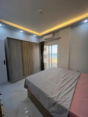 a bedroom with a large bed and a large window at Modern Beachfront Apartment 2 in Hurghada