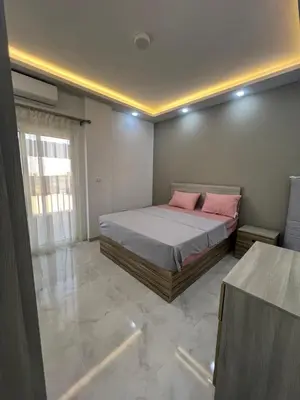 a bedroom with a bed with pink pillows on it at Modern Beachfront Apartment 2 in Hurghada