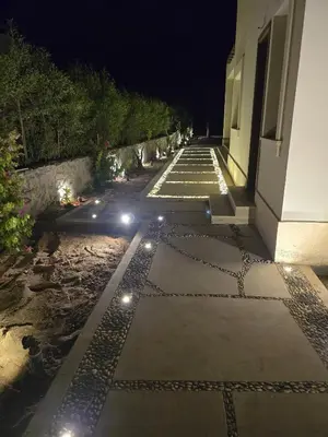 a walkway with lights next to a building at night at Villa at Cyan Ring with infinity pool at lagoon in Hurghada