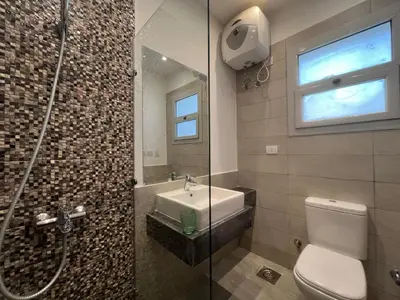 a bathroom with a toilet and a sink and a shower at Bright 2Bdr with Stunning Pool Views – Sholan 1 in Hurghada