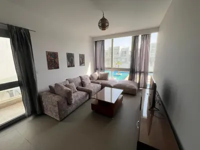 a living room with a couch and a table at Bright 2Bdr with Stunning Pool Views – Sholan 1 in Hurghada