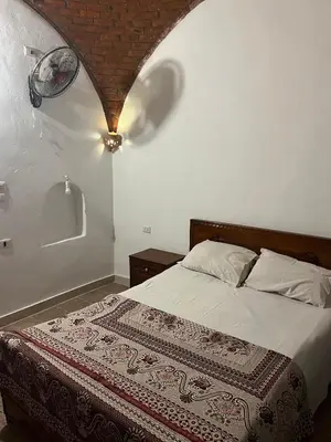 a bedroom with a bed with a blanket on it at Habu Palace in Luxor