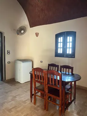 a dining room with a table and chairs and a window at Habu Palace in Luxor