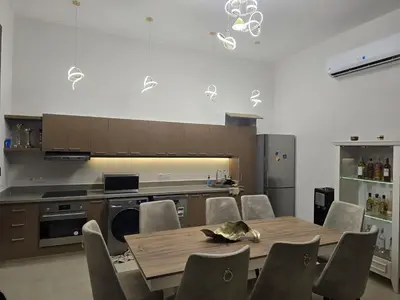 a dining room with a table and chairs and a kitchen at El Gouna Cyan Ringe Villa with infinity pool in Hurghada