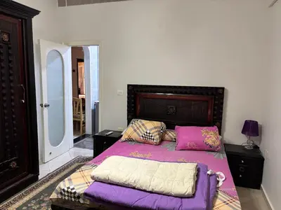 a bed with purple sheets and pillows in a bedroom at Apartment in Elhilal, Hurghada in Hurghada