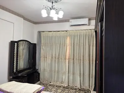 a bedroom with a curtain and a television and a chandelier at Apartment in Elhilal, Hurghada in Hurghada