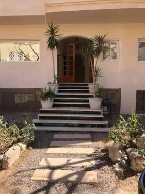 a house with stairs and potted plants in front of it at Apartment in Elhilal, Hurghada in Hurghada