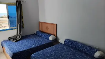a room with two beds and a window at Oasis Marena in Hurghada