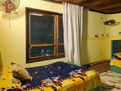 a bedroom with a bed and a window at Nubian Home by Sara in Nag` el-Ramla