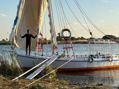 a man standing on a sail boat in the water at Mary sailboat adventure in Luxor