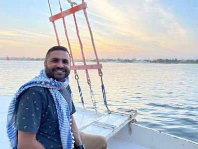 a man sitting on a boat in the water at Mary sailboat adventure in Luxor
