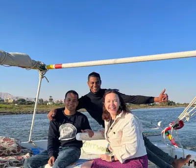 a group of three people sitting on a boat at Mary sailboat adventure in Luxor