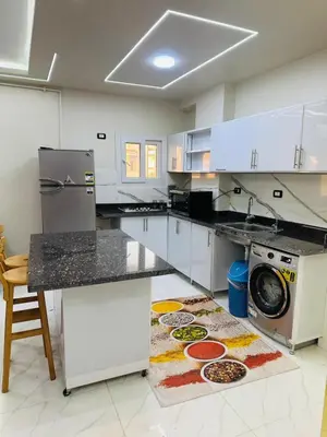 a kitchen with a washer and dryer on a rug at Elite Apartment Hurghada in Hurghada