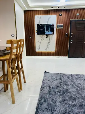 a living room with a tv and a table and chairs at Elite Apartment Hurghada in Hurghada