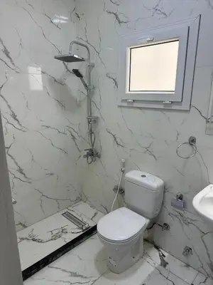 a white bathroom with a toilet and a sink at Elite Apartment Hurghada in Hurghada