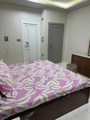 a bedroom with a bed with a purple and white comforter at Elite Apartment Hurghada in Hurghada