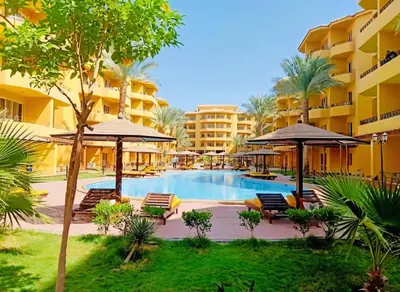 a pool at a resort with chairs and umbrellas at Elegant 2BR Retreat in Secure Resort Community in Hurghada