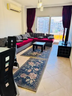 a living room with a couch and a tv at Elegant 2BR Retreat in Secure Resort Community in Hurghada