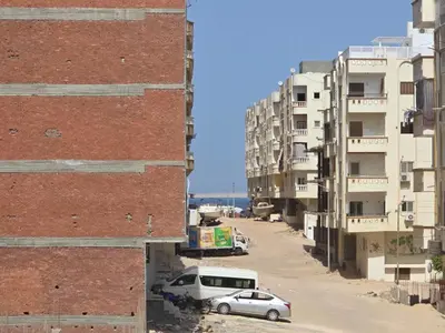 a city street with cars parked in front of buildings at Redsea - Hrghada - Arabia in Hurghada