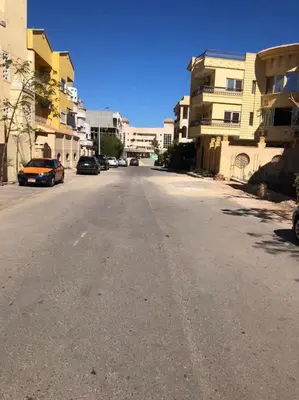 an empty street with parked cars and buildings at Waleed in Hurghada