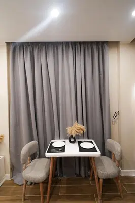 a table and chairs in front of a curtain at nile view modern studio- 7 min from aswan station in Aswan