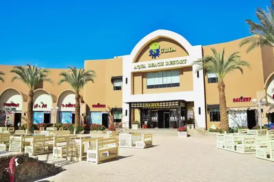 a shopping mall with palm trees in front of it at Al karma aqua beach in Hurghada