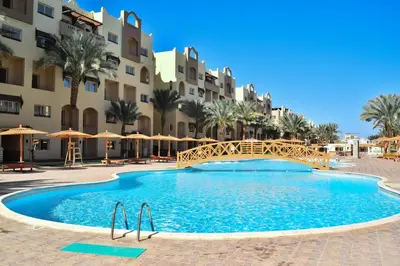 a swimming pool in front of a building with a resort at Al karma aqua beach in Hurghada