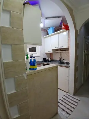 a kitchen with white cabinets and an archway at عرابيا امام فندق بيروت بجوار سوبر ماركت الخضري in Hurghada