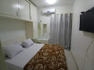 a small bedroom with a bed and a television at عرابيا امام فندق بيروت بجوار سوبر ماركت الخضري in Hurghada