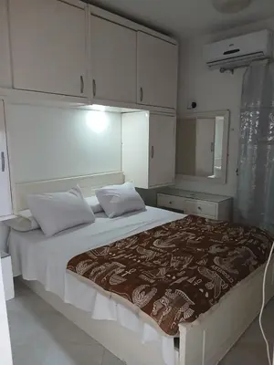 a bedroom with a large bed with white cabinets at عرابيا امام فندق بيروت بجوار سوبر ماركت الخضري in Hurghada